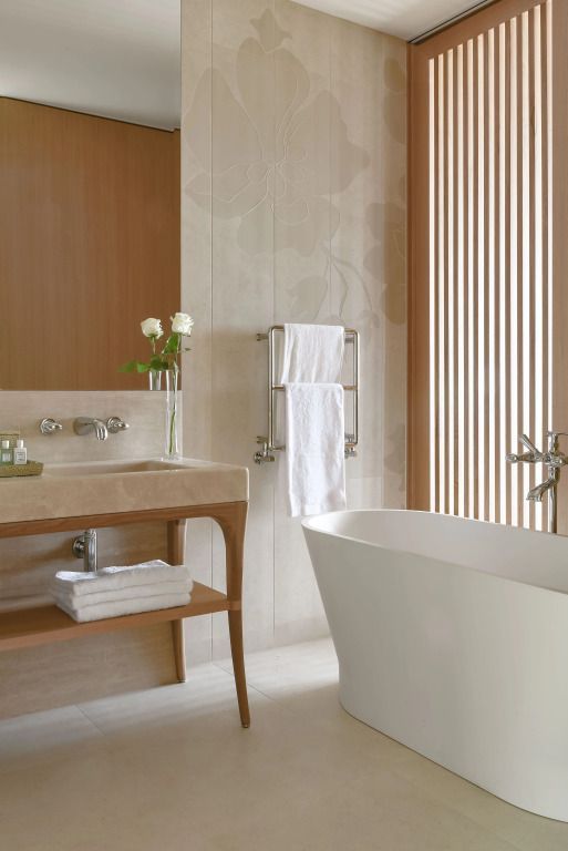 Elegantes Badezimmer mit freistehender Badewanne und stilvollem Waschtisch im Spa-Stil.