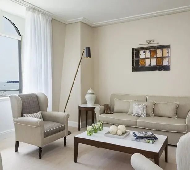 Eleganter Wohnbereich einer Suite mit Sofa und Sessel in neutralen Farben