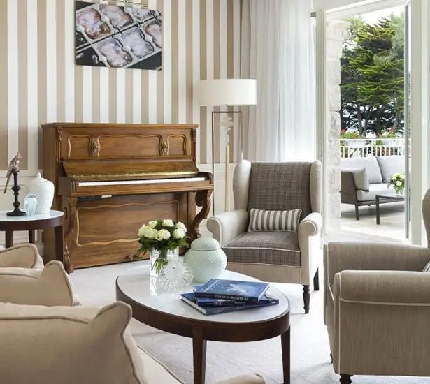 Elegantes Wohnzimmer der Royal Doppel Suite mit Klavier, gemütlichen Sesseln und Terrasse.