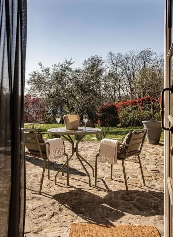Terrasse mit Blick auf Gartenlandschaft und gemütlichen Sitzgelegenheiten.