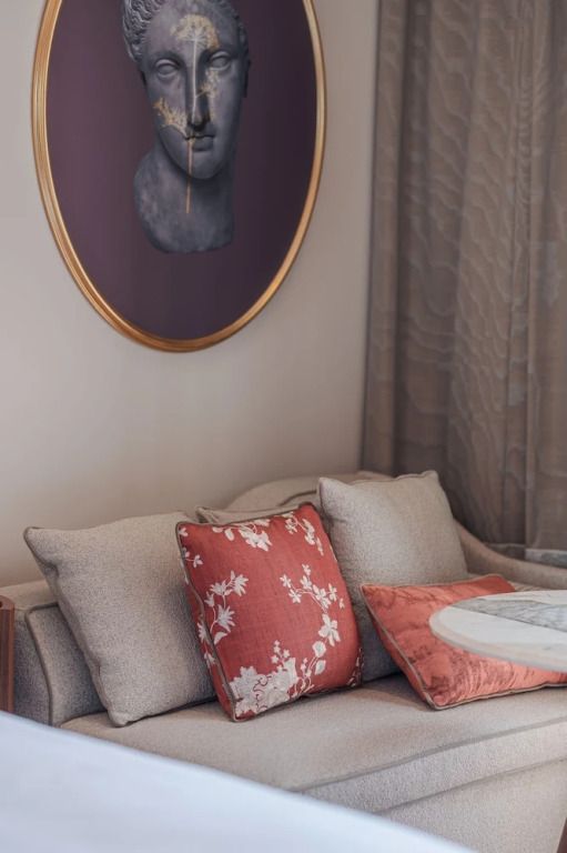 Detailaufnahme eines gemütlichen Sofas mit dekorativen Kissen und Kunst an der Wand