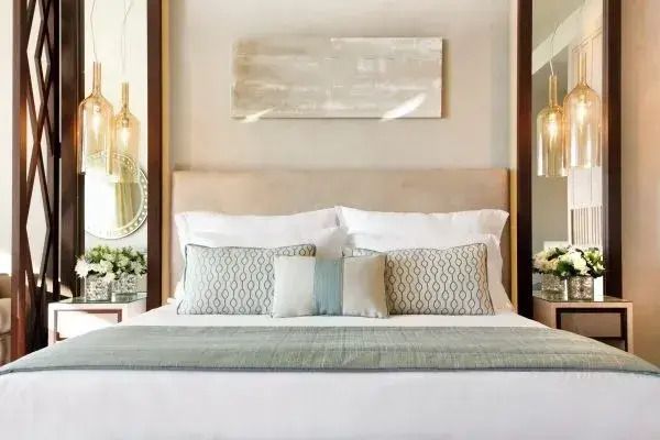 Elegantes Doppelbett mit stilvoller Beleuchtung und dekorativen Kissen