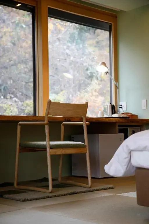 Arbeitsbereich mit großem Fenster und Aussicht im Satoyama Jujo Hotel