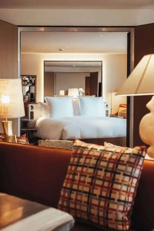 Stilvolle Hotelzimmeransicht mit Doppelbett und geschmackvollen Lampen