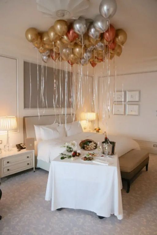 Gemütliches Zimmer mit Dekorationen an der Decke und Sekt auf einem Tisch.