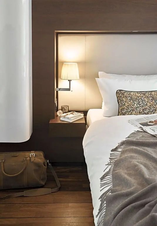 Elegantes Doppelbett mit stilvoller Beleuchtung und dekorativem Kissen.