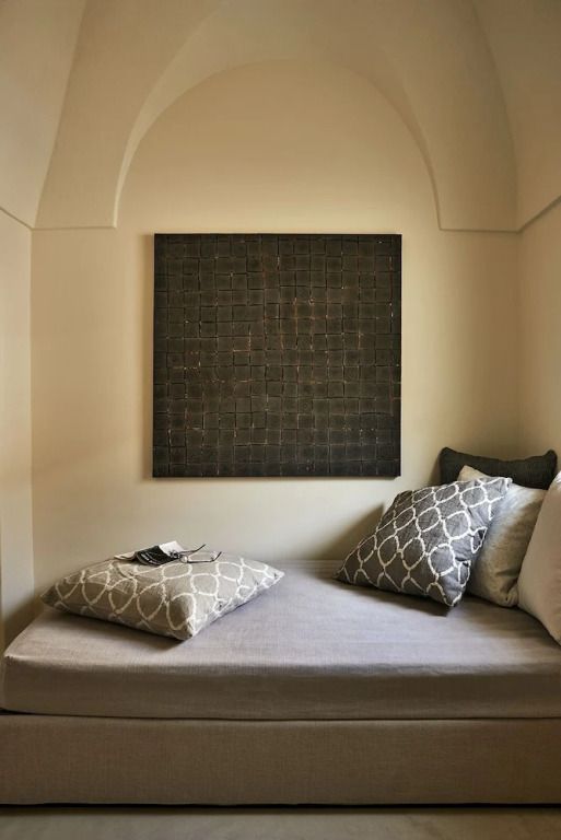Gemütliche Sitzecke mit weichen Kissen und Wandkunst.