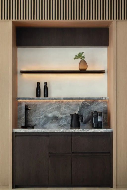 Luxuriöse Minibar mit dunkler Holzoptik und Designerbeleuchtung