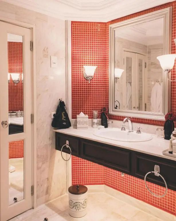 Modernes Badezimmer im Sofitel Legend Metropole Hanoi mit roten Fliesen und großzügigem Waschbereich