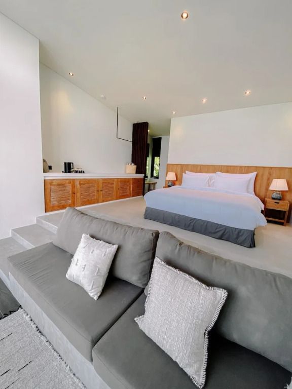 Geräumiges Schlafzimmer mit gemütlicher Sitzecke und Beleuchtung