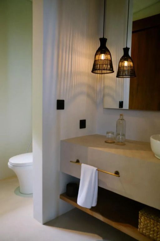 Moderner Badezimmerbereich mit Designerleuchten und eleganter Waschbeckenanordnung