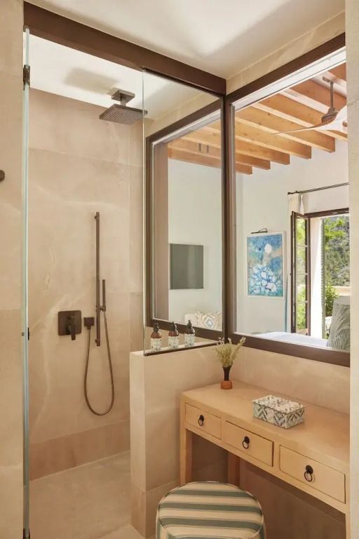 Modernes Badezimmer mit Dusche und Fenster zum Schlafzimmer