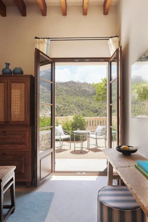 Raum mit Holzmöbeln und Balkon mit Bergblick