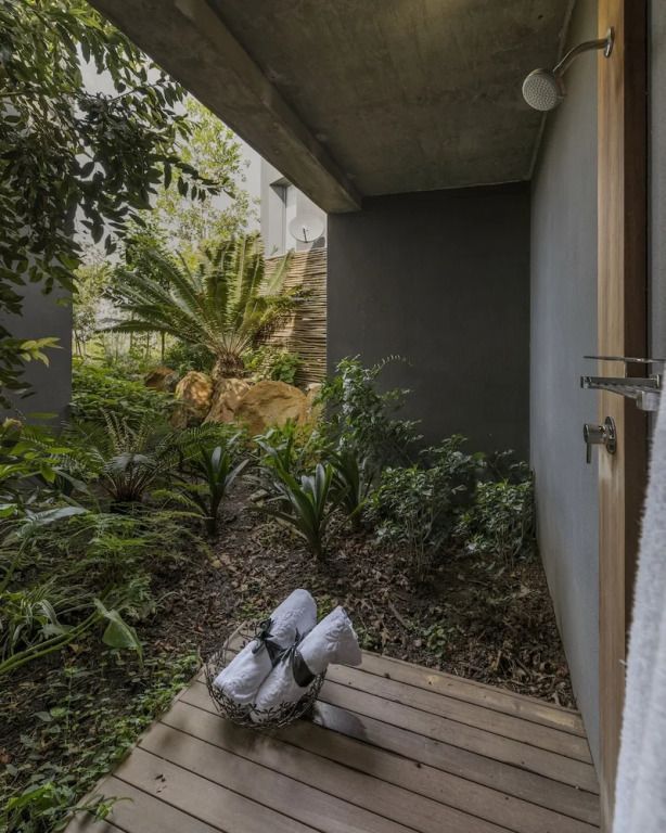 Privater Gartenbereich der Villa mit üppiger Bepflanzung und Holzboden.