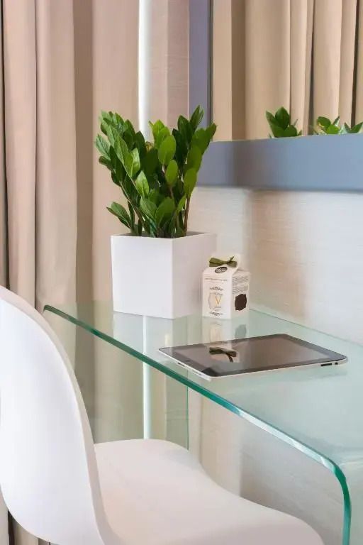Moderner Schreibtisch mit Pflanze und Tablet in einem Hotelzimmer