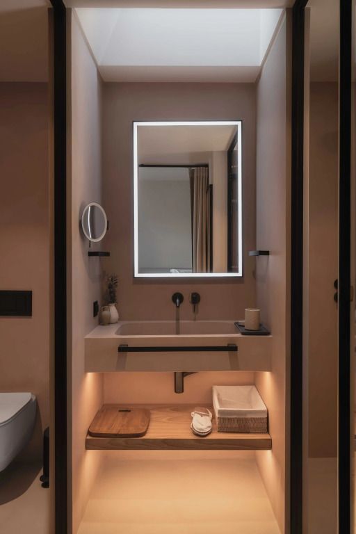Stilvolles Badezimmer mit beleuchtetem Spiegel und edlen Armaturen im Stamna Sifnos Hotel.