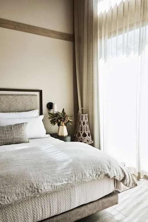 Elegantes Hotelzimmer mit großem Bett und natürlichem Licht durch bodentiefe Fenster