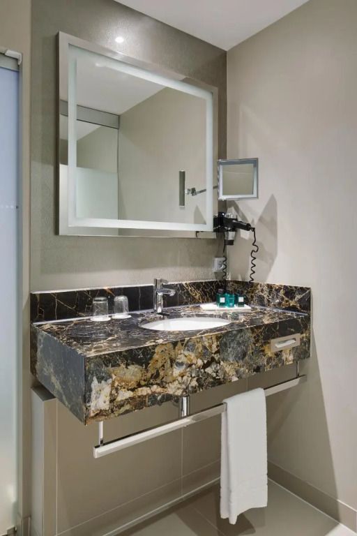 Modernes Badezimmer mit elegantem Marmorwaschbecken und großem Spiegel
