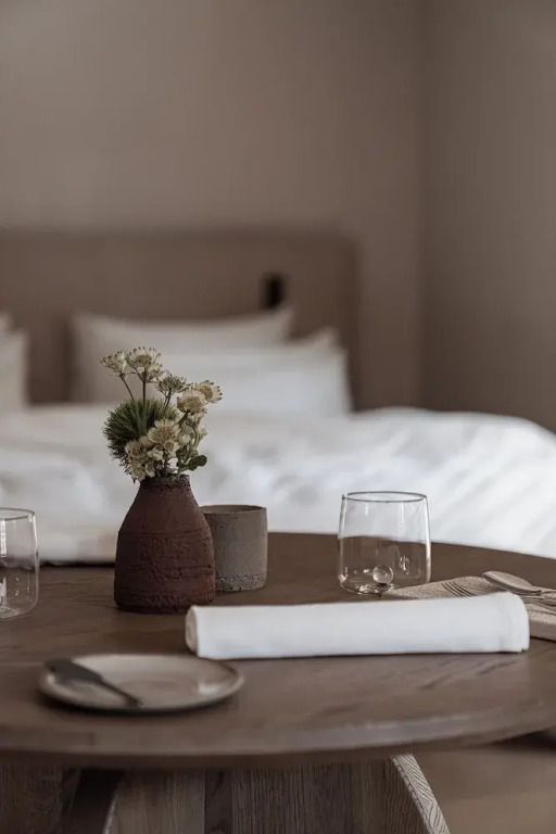 Tischdeko in moderner Suite mit Blumen und Glaswaren.