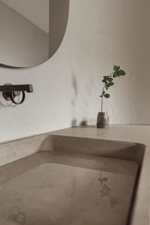 Modernes Badezimmerdetail mit Waschbecken und minimalistischer Dekoration.