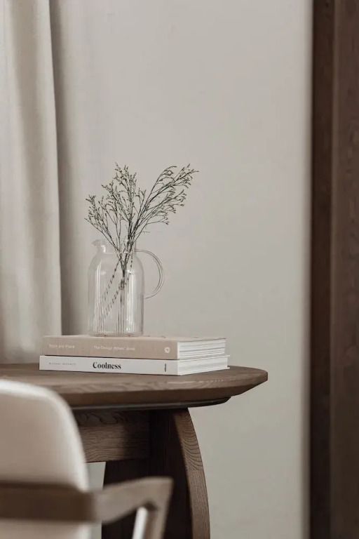 Detailaufnahme eines dekorativen Tisches mit Blumen und Büchern.