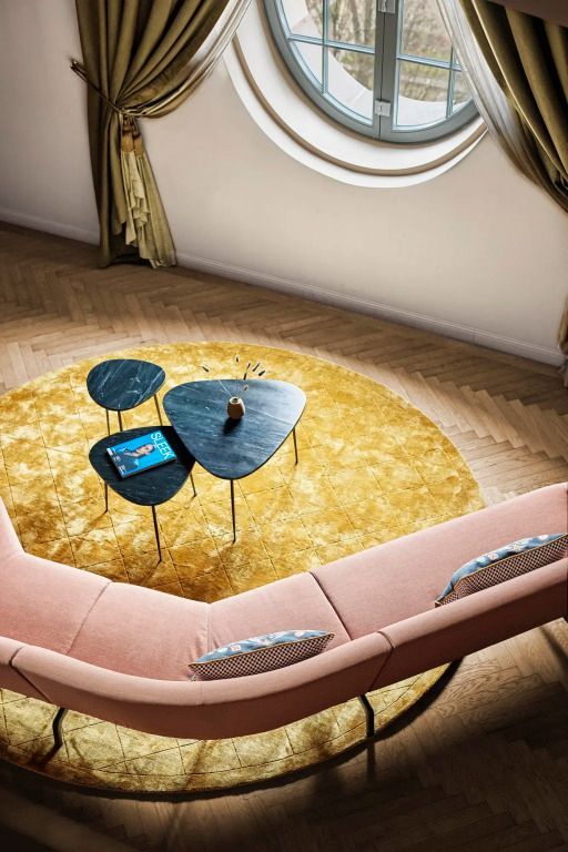 Einladende Lounge mit rosafarbenem Sofa und runden Beistelltischen