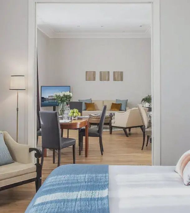 Gemütliches Wohnzimmer mit Esstisch und Doppelbett in der Grand Doppel Suite.