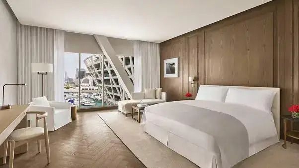 Luxuriöses Zimmer mit Doppelbett, Holzwandverkleidung und großem Fenster mit Aussicht