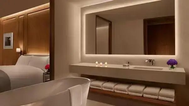 Stilvolles Badezimmer mit freistehender Badewanne und beleuchtetem Spiegel