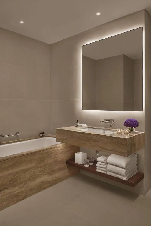 Luxuriöses Badezimmer mit einer großen Badewanne und einem beleuchteten Spiegel.
