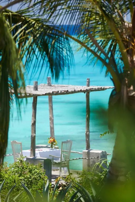 Romantische Dinnerecke direkt am Meer mit türkisblauem Wasser im Hintergrund