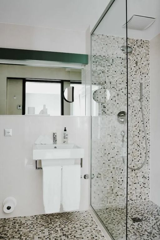 Modernes Badezimmer mit glasierter Dusche und stilvoller Waschtischausstattung