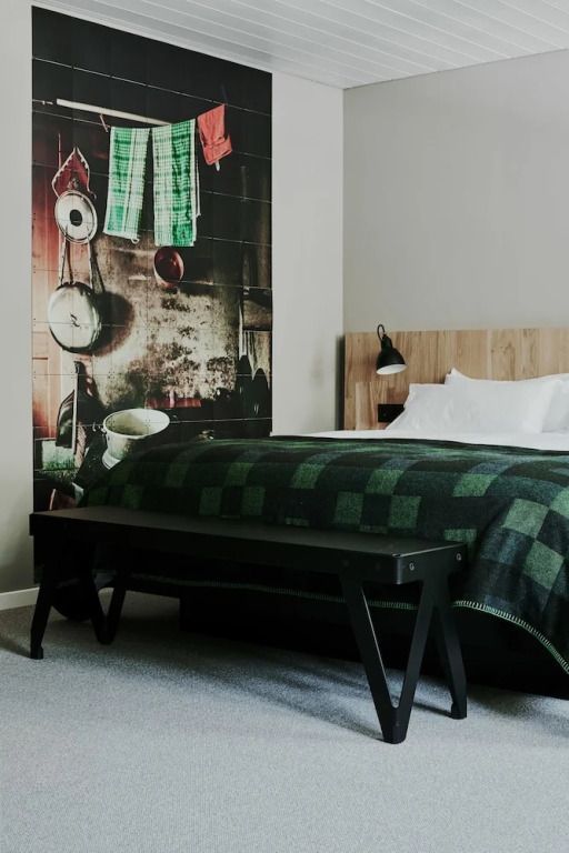 Bett in einem Zimmer mit kunstvollem Wandbild und stilvoller Beleuchtung