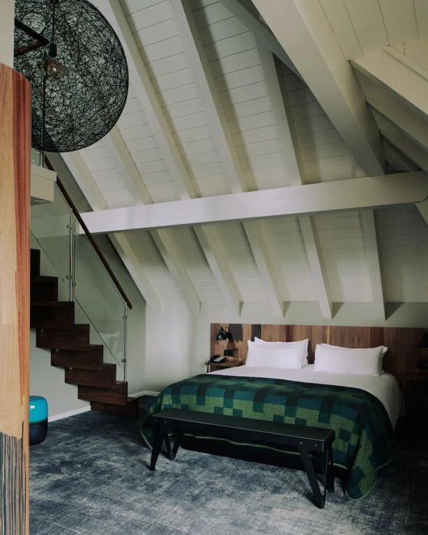 Komfortable Suite mit Doppelbett und Holzdekor unter Schrägdach