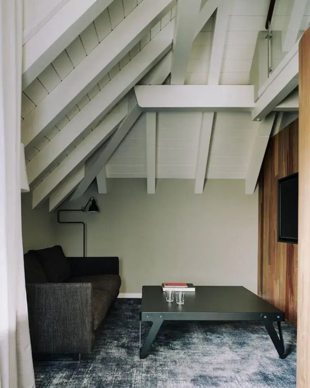 Gemütliche Sitzecke mit einem Sofa unter einer Holzbalkendecke
