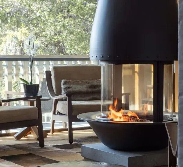 Gemütlicher Kamin in moderner Suite mit Sitzbereich und natürlichem Licht.