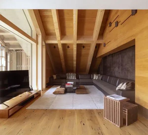 Großzügiger Wohnbereich in der Furka Suite mit Holzelementen und Sofa.
