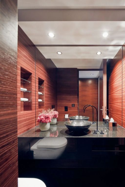 Elegantes Badezimmer mit Holzverkleidung und modernen Armaturen, dekoriert mit Blumen