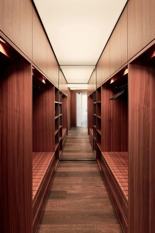 Luxuriöser begehbarer Kleiderschrank mit Holzverkleidung und Regalen.