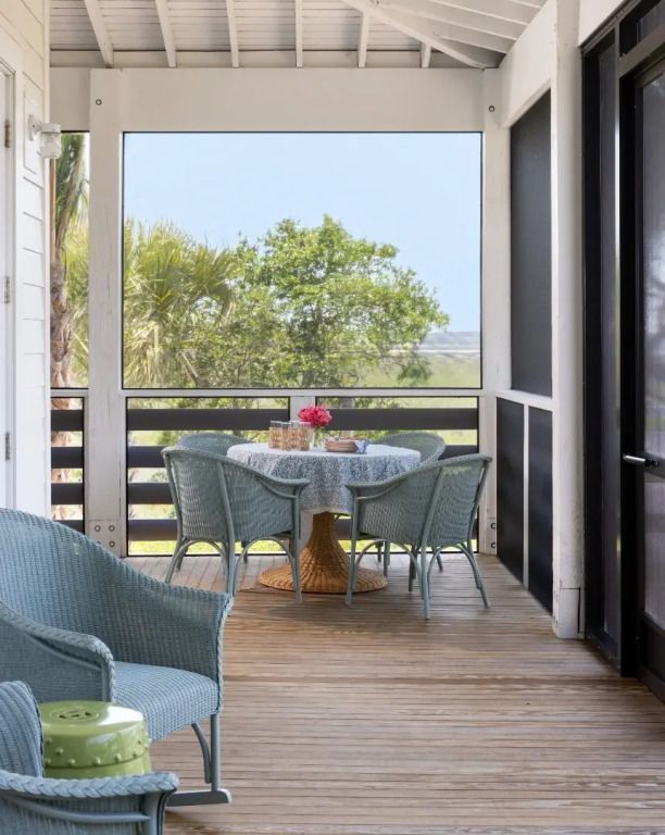 Veranda-Sitzbereich mit Tisch und Stühlen und Blick auf die Natur in der Sweetbay Suite