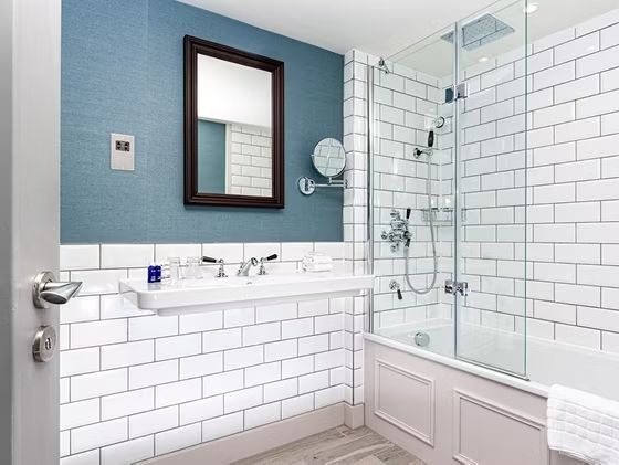 Modernes Badezimmer mit weißen Fliesen und Glasdusche