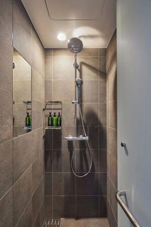 Moderne Dusche mit grauen Fliesen und stilvollen Armaturen