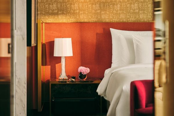 Elegantes Schlafzimmer mit roter Akzentwand und Tischlampe