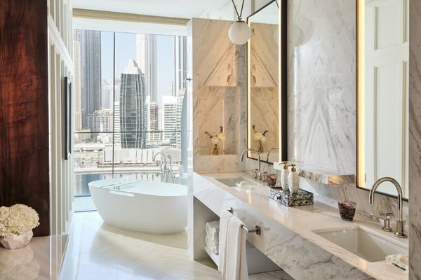 Marmorbadezimmer mit freistehender Badewanne und Skyline-Blick