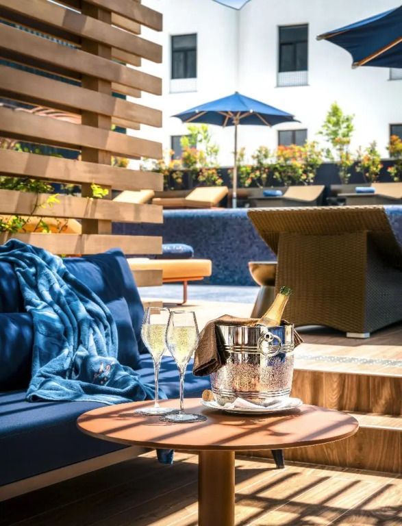 Entspannungsbereich mit Liegen und Champagner auf einem Tisch. Elegante Outdoor-Ecke im Hotel.