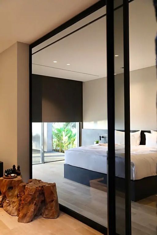 Elegantes Schlafzimmer mit großem Bett und Glaswänden in einer luxuriösen Villa