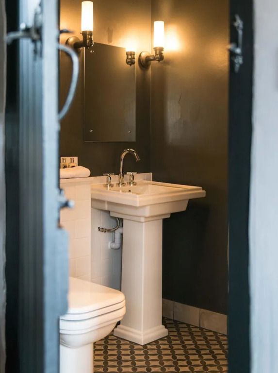 Kleines Badezimmer mit Waschbecken und stilvoller Beleuchtung.
