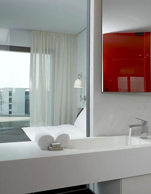 Helles Badezimmer mit Blick ins Schlafzimmer, elegante Ausstattung.