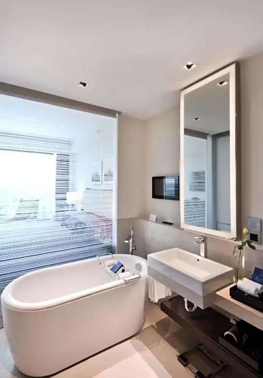 Modernes Badezimmer mit freistehender Badewanne und großem Spiegel