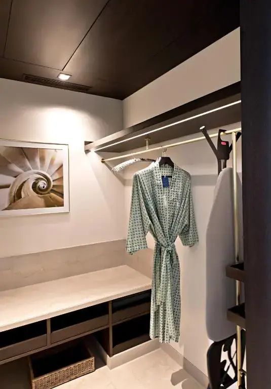 Ankleidezimmer mit Bademantel und dezenter Kunst an der Wand